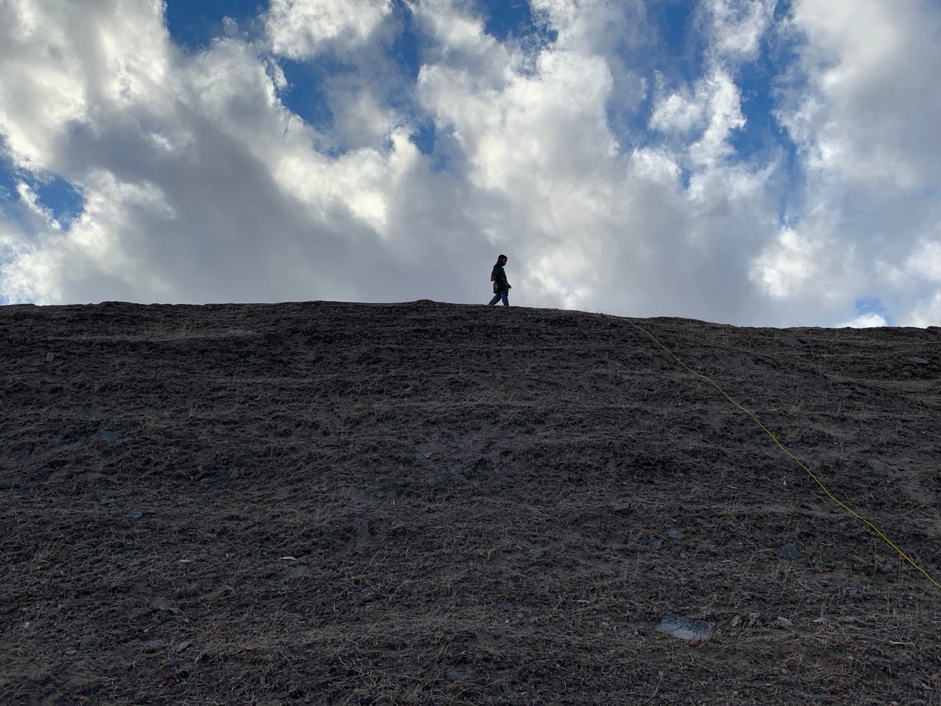 Vineyard work on the Kadenge Estate hillside under clouds